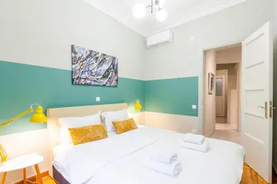 a bedroom with a white bed and a blue wall at Acropolis Apartments in Athens