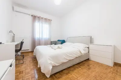a white bedroom with a bed and a desk at Fresh and Clean apt for 6 in Koukaki in Athens