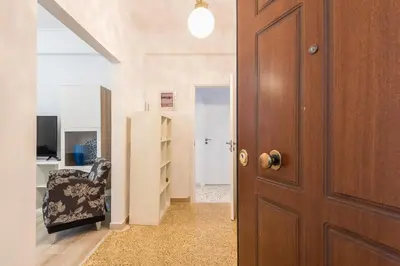 a hallway with a wooden door and a chair at Fresh and Clean apt for 6 in Koukaki in Athens