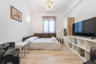 a living room with a bed and a flat screen tv at Fresh and Clean apt for 6 in Koukaki in Athens