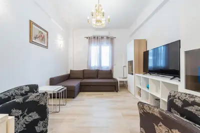 a living room with a couch and a flat screen tv at Fresh and Clean apt for 6 in Koukaki in Athens