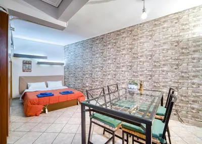 a room with a table and a brick wall at Athens metro apartment in Athens