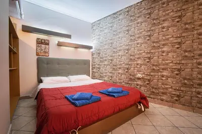 a bedroom with a red bed with two blue towels on it at Athens metro apartment in Athens