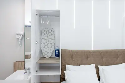 a bedroom with white walls and a bed with a mirror at My Athens Place in Athens