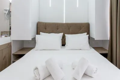 a bed with white pillows in a bedroom at My Athens Place in Athens