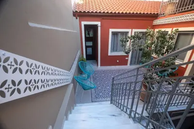 a stairway leading to a red house with a blue seat at ATHENIAN YARD SUITES in Athens