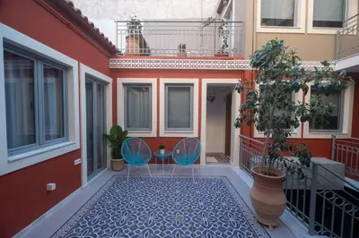 a balcony with two chairs and a table on a building at ATHENIAN YARD SUITES in Athens