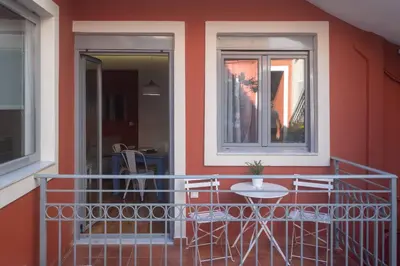 a balcony with chairs and a table and a window at ATHENIAN YARD SUITES in Athens