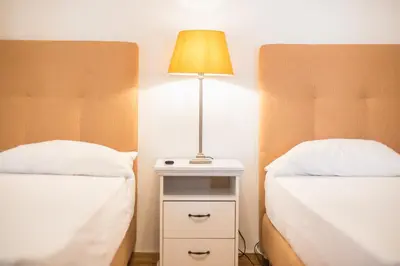 a bedroom with two beds and a lamp on a night stand at Athens Empire Paradise Apartment in Athens