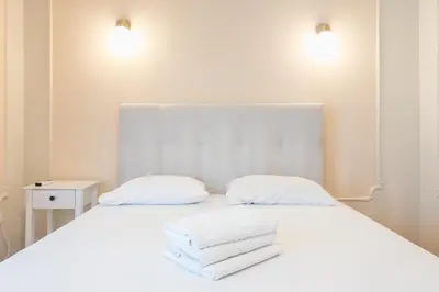a white bed with two white towels on it at Athens Empire Paradise Apartment in Athens