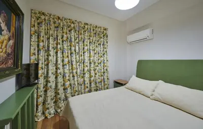 a small bedroom with a bed and a curtain at Luxury 4 Bdrm Villa with Pvt Pool on the beach in Lagonissi