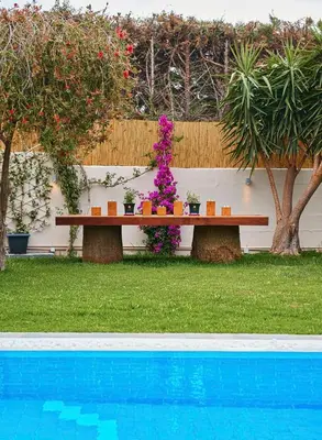 a picnic table next to a pool with flowers at Luxury 4 Bdrm Villa with Pvt Pool on the beach in Lagonissi