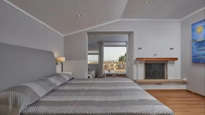 a bedroom with a bed and a fireplace at Luxury 4 Bdrm Villa with Pvt Pool on the beach in Lagonissi