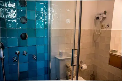 a bathroom with a glass shower with a toilet at Kyria Boutique House in Athens