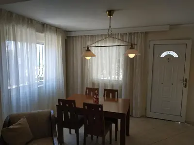 a dining room with a table and chairs and a room at Near Airport And metropolitan Artemis George Cozy Home in Artemida