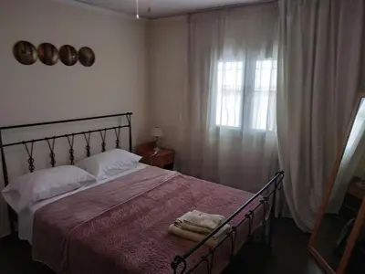 a bedroom with a large bed and a window at Near Airport And metropolitan Artemis George Cozy Home in Artemida