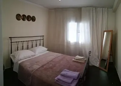 a bedroom with a large bed and a mirror at Near Airport And metropolitan Artemis George Cozy Home in Artemida