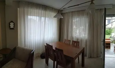 a dining room with a table and chairs and a window at Near Airport And metropolitan Artemis George Cozy Home in Artemida