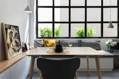 a dining room with a table and chairs and windows at La Maison Athenes in Athens