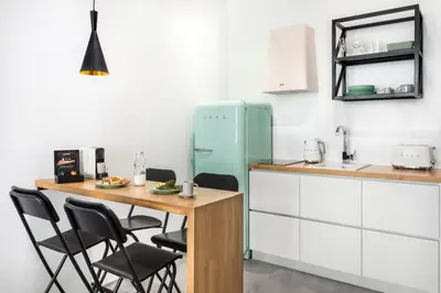 a kitchen with a table and a blue refrigerator at La Maison Athenes in Athens