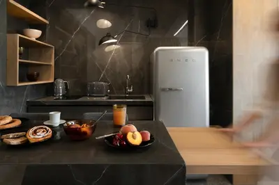 a kitchen with a black counter with a refrigerator at La Maison Athenes in Athens