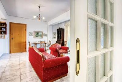a living room with two red chairs and a table at A gem next to the sea and close to the airport in Dhaskalión