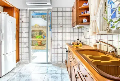 a kitchen with a sink and a refrigerator at A gem next to the sea and close to the airport in Dhaskalión