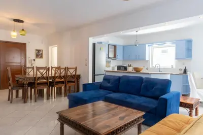 a living room with a blue couch and a table at Luxury and Spacious apt for 8 guests New features April 2025 in Athens