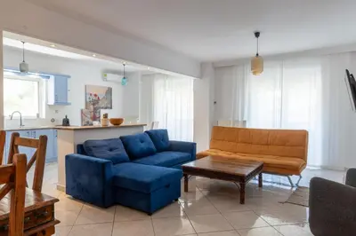 a living room with a blue couch and a table at Luxury and Spacious apt for 8 guests New features April 2025 in Athens