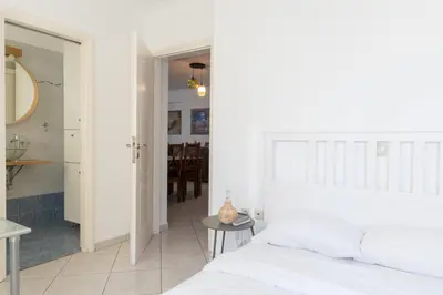 a bedroom with a white bed and a dining room at Luxury and Spacious apt for 8 guests New features April 2025 in Athens