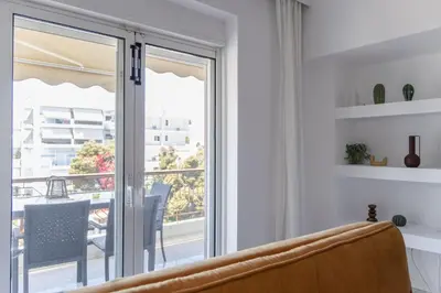 a living room with a sliding glass door to a balcony at Luxury and Spacious apt for 8 guests New features April 2025 in Athens