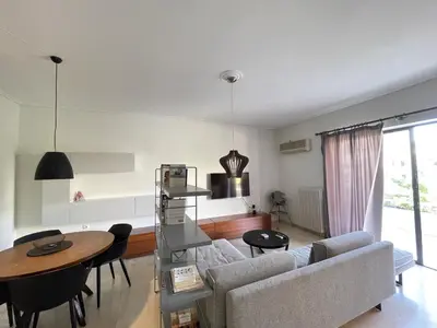 a living room with a couch and a table at Kleio - Spacious apartment in Glyfada in Athens