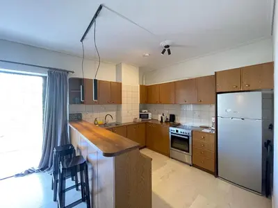 a kitchen with wooden cabinets and a white refrigerator at Kleio - Spacious apartment in Glyfada in Athens