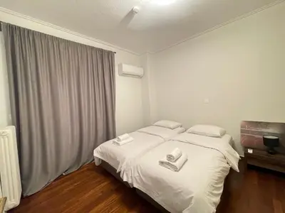 a bedroom with a bed with two towels on it at Kleio - Spacious apartment in Glyfada in Athens