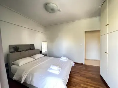 a bedroom with a large white bed with towels on it at Kleio - Spacious apartment in Glyfada in Athens