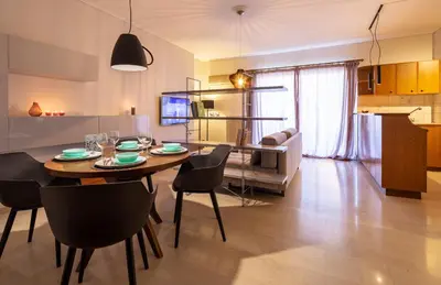 a dining room and living room with a table and chairs at Kleio - Spacious apartment in Glyfada in Athens
