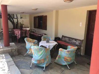 a room with chairs and a table and a table and a table and chairs at Your Holiday House in Porto Rafti