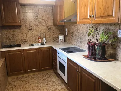a kitchen with wooden cabinets and a stove top oven at Your Holiday House in Porto Rafti
