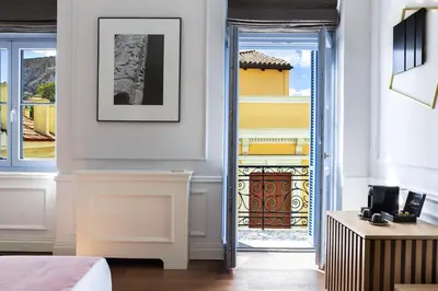 a bedroom with a door open to a balcony at A77 Suites, Small Luxury Hotels of the World in Athens