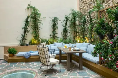 a patio with a couch and a table and chairs at A77 Suites, Small Luxury Hotels of the World in Athens