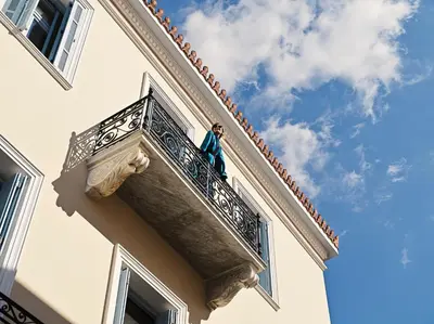 a man standing on a balcony of a building at A77 Suites, Small Luxury Hotels of the World in Athens
