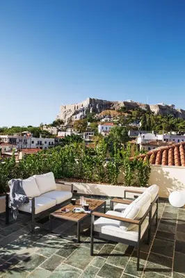 a patio with couches and a table with a view at A77 Suites, Small Luxury Hotels of the World in Athens