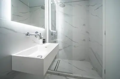 a white bathroom with a sink and a mirror at Heritage Boutique Apartments in Athens