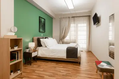 a bedroom with a bed and a green wall at Monastiraki Urban Apartments in Athens
