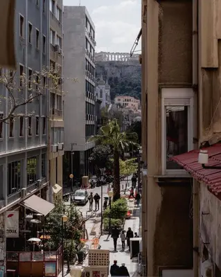 a city street with buildings and people walking on the sidewalk at Monastiraki Urban Apartments in Athens