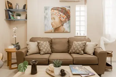 a living room with a couch and a painting of a woman at Monastiraki Urban Apartments in Athens