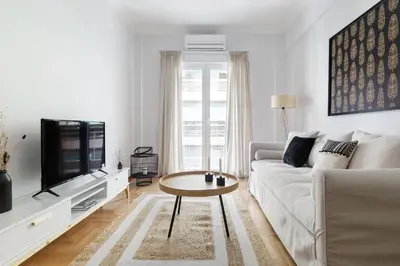 a white living room with a couch and a tv at Urban 2BD Apartment in Koukaki by UPSTREET in Athens