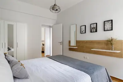 a bedroom with a bed and a wall with mirrors at Urban 2BD Apartment in Koukaki by UPSTREET in Athens