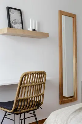 a rattan chair sitting in front of a mirror at Urban 2BD Apartment in Koukaki by UPSTREET in Athens
