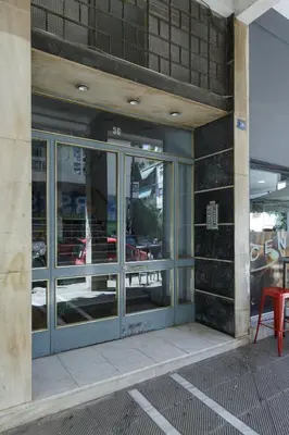 a front door of a restaurant with a red chair at Urban 2BD Apartment in Koukaki by UPSTREET in Athens